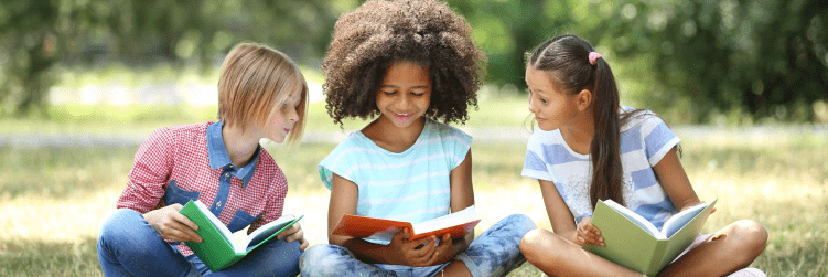 três meninas sentadas em roda lendo livros