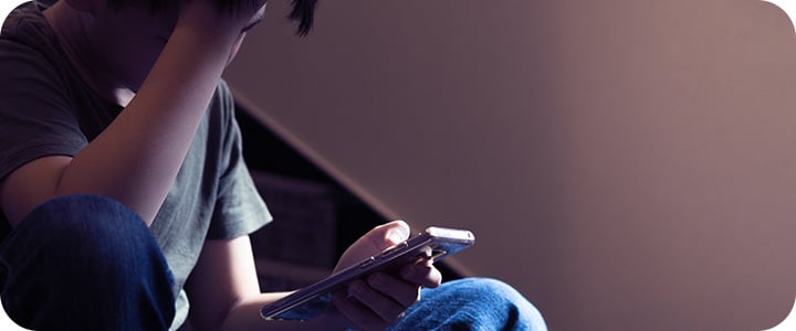 Jovem sentado nas escadas triste por sofrer cyberbullying | Sponte